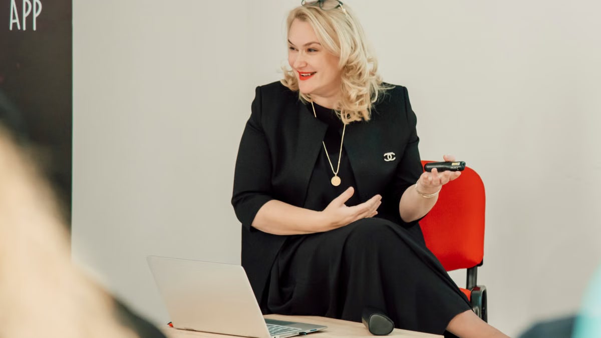 Confident woman presenting in a modern office setting with a smile.